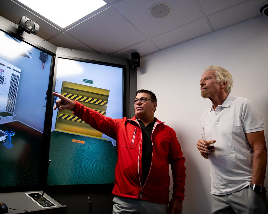 person points at a screen - man looks on with interest - Maritime Skills Academy Simulator Centre opens